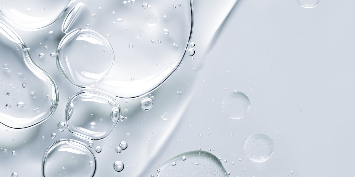 Close-up of clear oil with bubbles on a light gray background