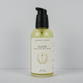A bottle of Meadows & Myth's Oath Aromatic Woods + Resins + Soft Spots body oil, featuring a black pump dispenser and a cream-colored label with gold detailing, set against a plain light gray background.