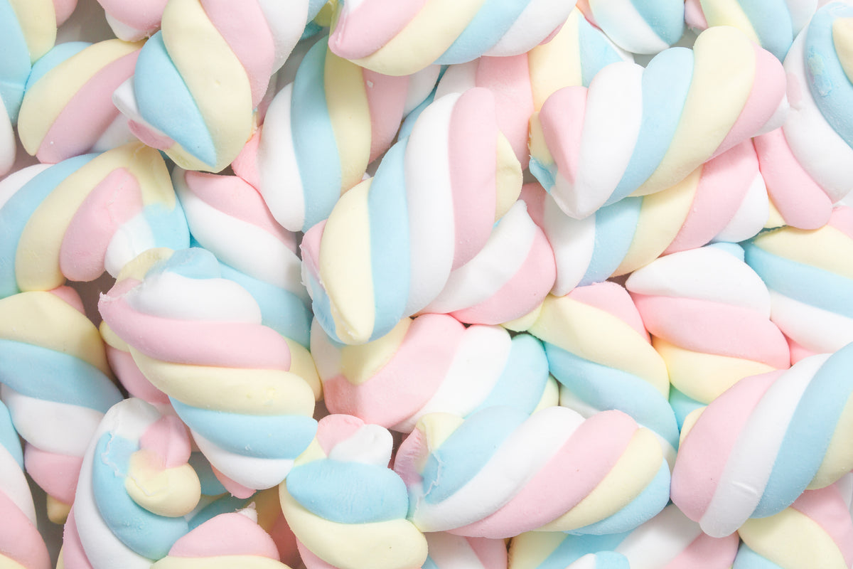 Close-up of pastel pink, blue, yellow, and white twisted marshmallow candies piled together.